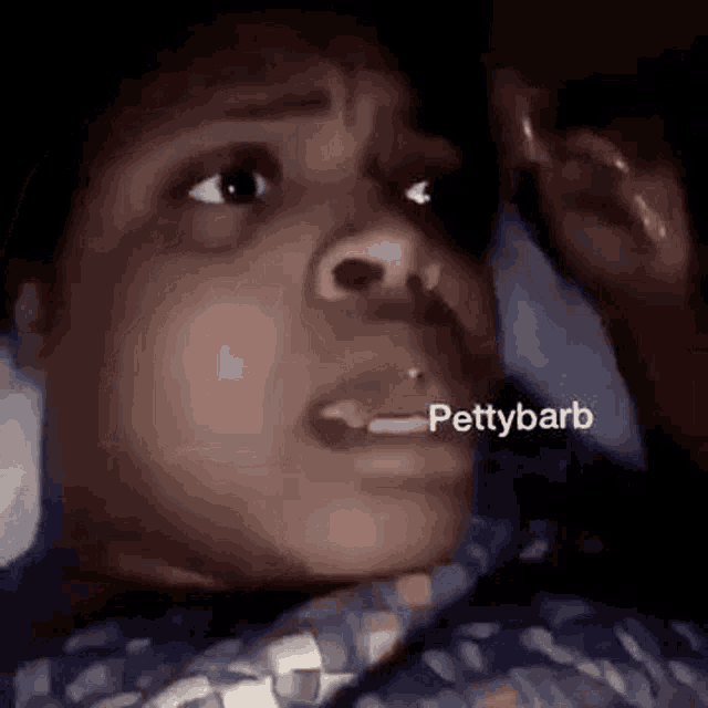 a close up of a person 's face with the word pettybarb written on it .