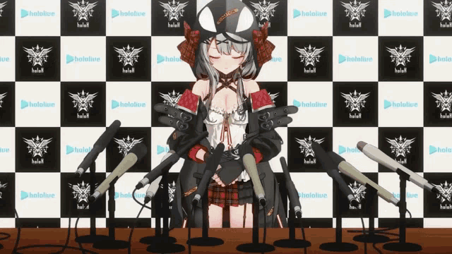 a girl is standing in front of a wall with hololive written on it
