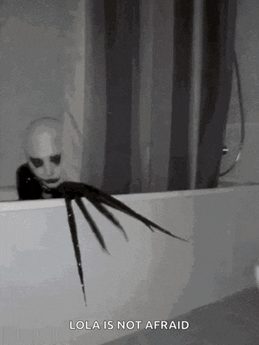 a scary clown is sitting in a bathtub with a shower curtain behind him .