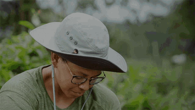 a woman wearing glasses and a hat with the word sorry above her