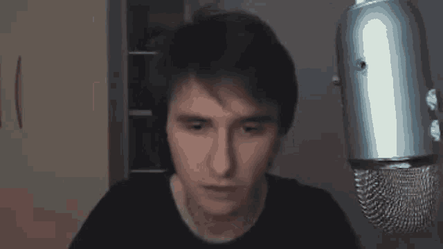 a man is standing in front of a microphone and making a face .