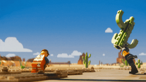 a lego man standing next to a cactus with a sticker on his back that says ' emmett ' on it