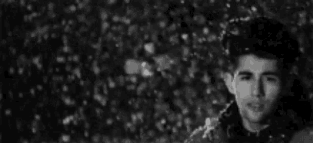 a man is standing in the snow looking at the camera .