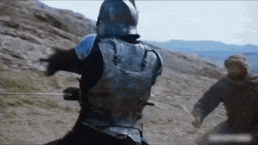 a man in armor is riding a horse and holding a sword .