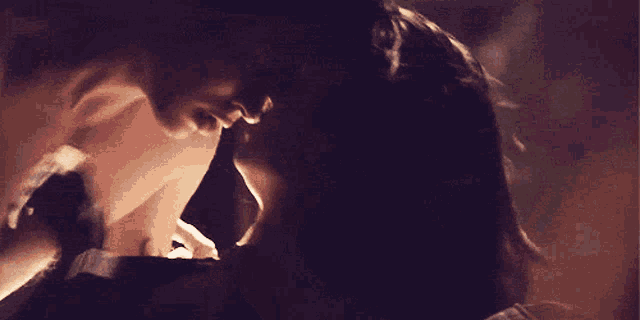 a man and a woman are kissing and the woman is holding the man 's head