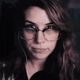 a close up of a woman wearing glasses and earphones .
