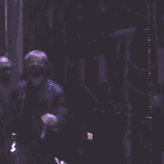 a person wearing a mask and glasses is holding a microphone .