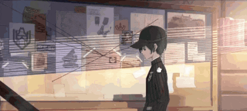 a man in a black hat is standing in front of a bulletin board with posters on it .