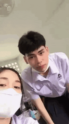a boy and a girl wearing masks are standing next to each other .