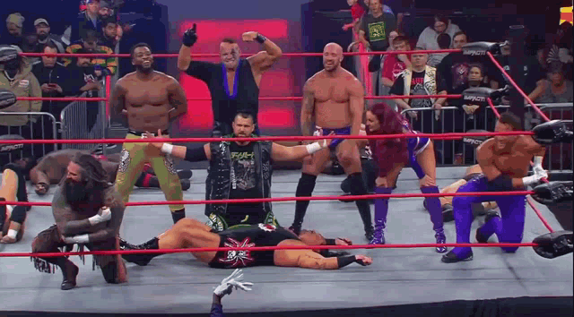 a group of wrestlers are posing in a ring with one wearing a shirt that says smack down