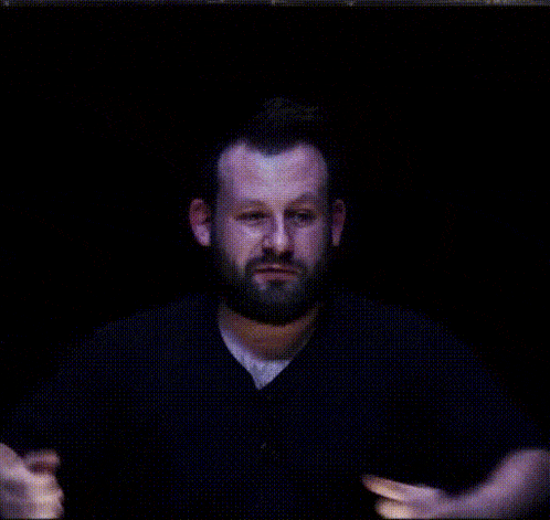 a man with a beard is giving a thumbs up with his hands