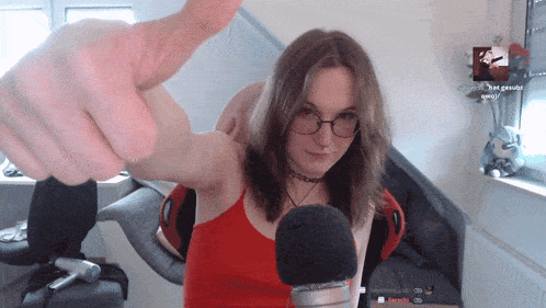 a woman wearing glasses giving a thumbs up