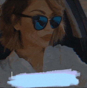 a woman wearing sunglasses and a white shirt