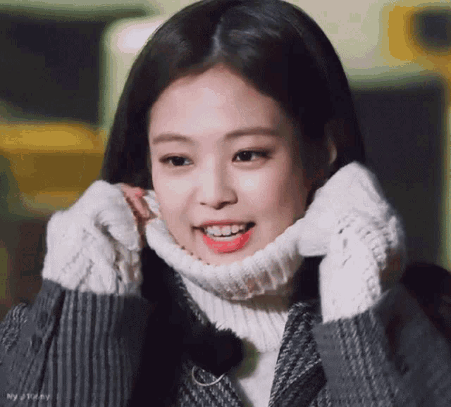 a close up of a person wearing a sweater and gloves .