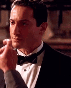 a man in a tuxedo with a bow tie is being touched