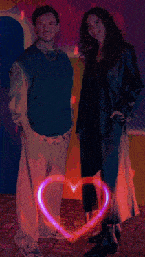 a man and a woman standing next to each other with a heart in the middle