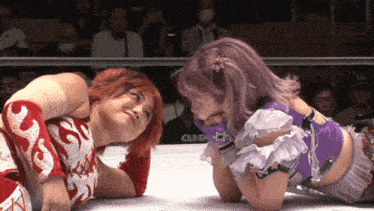 two women wrestling in a ring with a sign that says e26