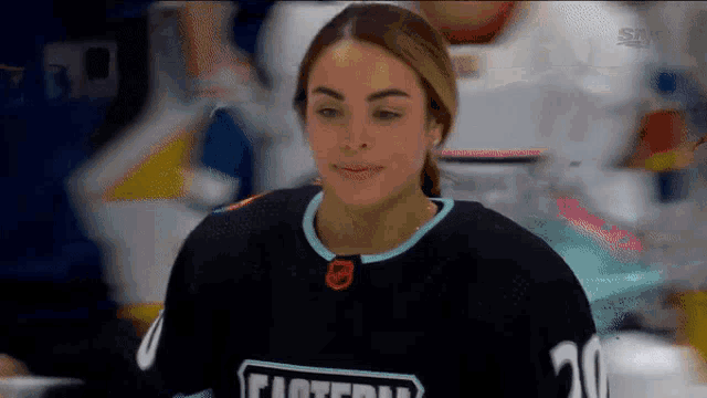 a woman wearing a hockey jersey with the number 20