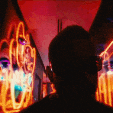 a person is looking at a neon sign that says ' a ' on it