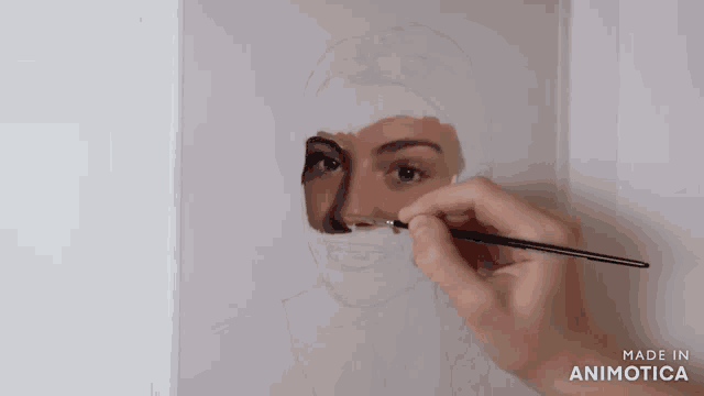 a person is painting a woman 's face with a brush and the words made in animatica on the bottom