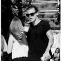 a man and woman are standing next to each other in a black and white photo .