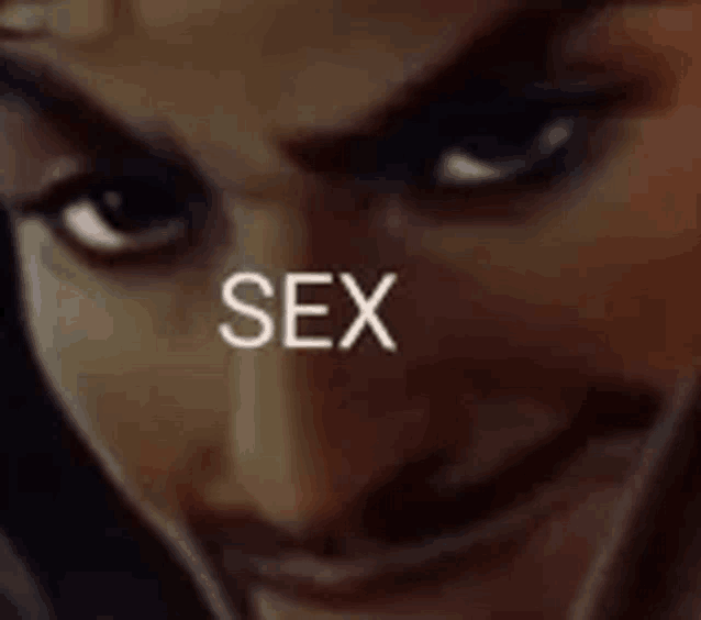 a close up of a person 's face with the word sex written in white .