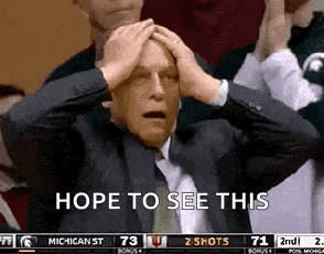 a man in a suit and tie is holding his head in his hands .