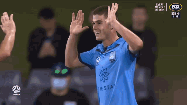 a man in a blue shirt that says the star applauds