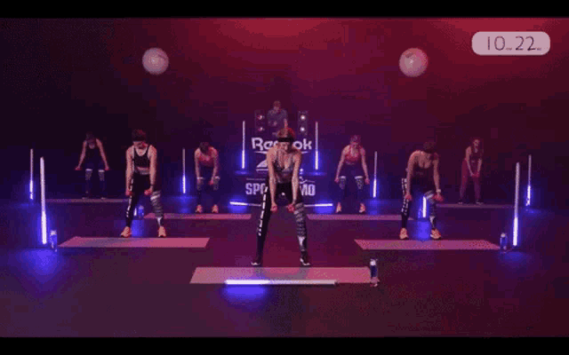 a group of women are doing exercises in front of a reebok logo