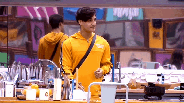 a man wearing a yellow sweatshirt with a black strap around his waist