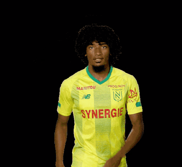 a man in a yellow shirt with synergy on it