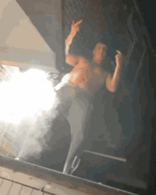 a shirtless man is taking a picture of himself in the mirror