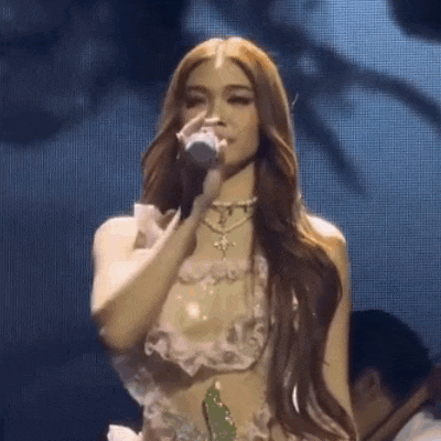 a woman singing into a microphone on a stage .