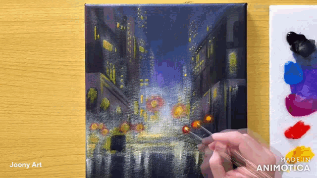 a painting of a city at night is being made by joony art