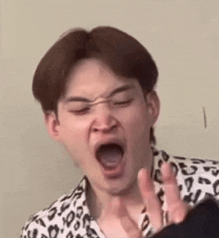 a young man is making a funny face with his mouth open .