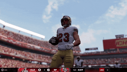 a football player with the number 23 on his jersey is holding a football