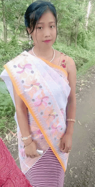 a woman wearing a striped skirt and a white shawl with flowers on it
