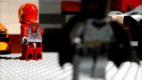 a lego figure of iron man is standing next to a batman figure