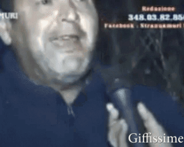 a man is talking into a microphone with the words giffissime written below him