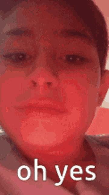 a close up of a person 's face with a red background and the words `` oh yes '' written on it .