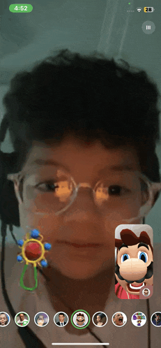 a young boy wearing glasses and headphones is playing a video game with mario