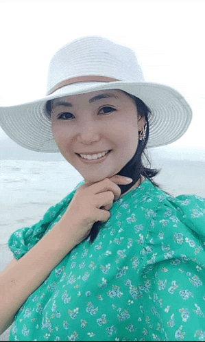 a woman wearing a white hat and a green floral dress