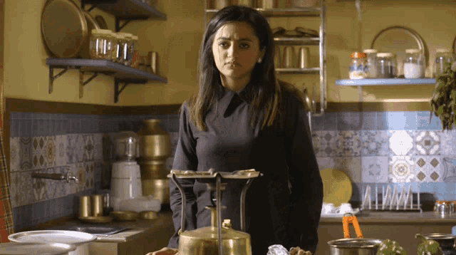 a woman stands in a kitchen with a brass scale
