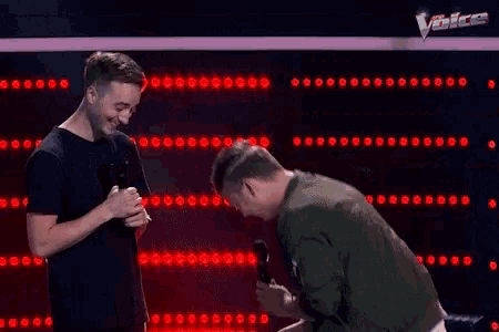 a man is holding a ring in front of another man who is asking if he will marry him .