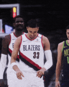 a basketball player wearing a blazers 33 jersey stands on the court