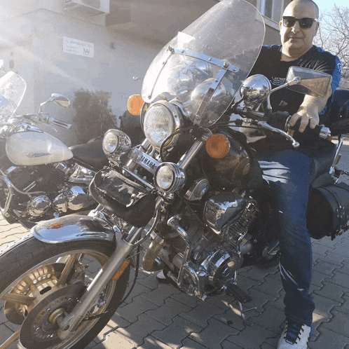 a man sitting on a yamaha motorcycle with a windshield