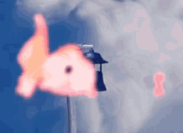 a pink fish is hanging from a pole next to a street light