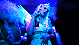 a woman in a fairy costume is holding a drink