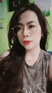 a woman wearing glasses and a tank top with the letter s on it