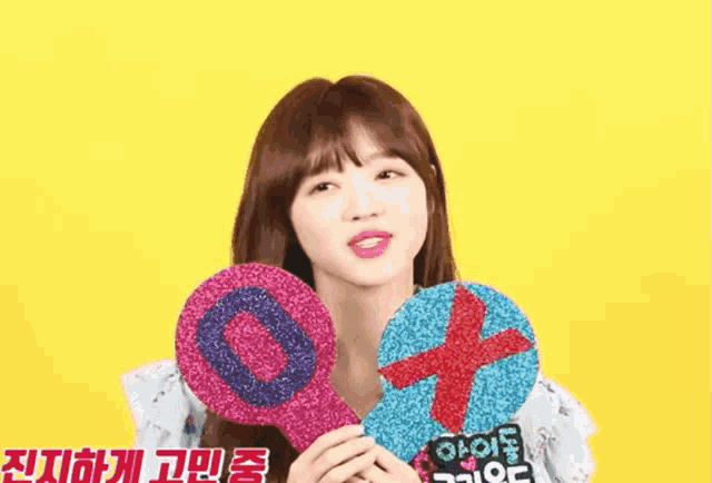 a girl is holding a number 0 and a cross in her hands
